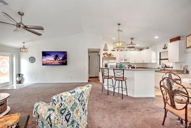 interior space with ceiling fan, vaulted ceiling, and light carpet