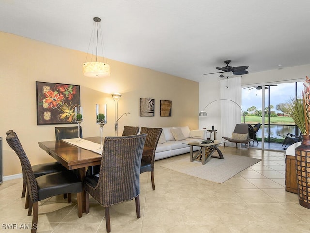 tiled dining area featuring a water view and ceiling fan