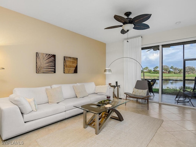 tiled living room with a water view and ceiling fan