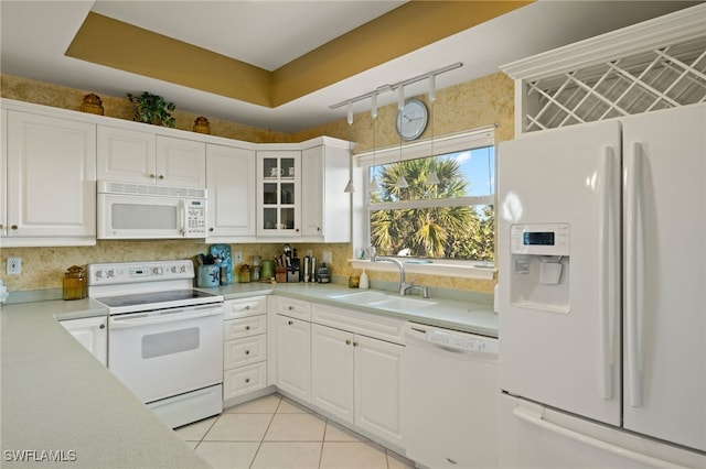 kitchen featuring white appliances, sink, and white cabinets