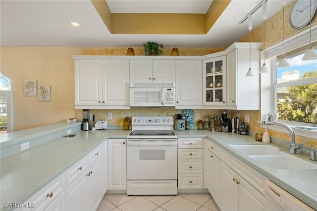 kitchen with sink, white cabinets, and white appliances