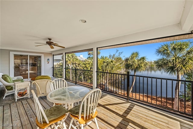 sunroom with a water view and ceiling fan