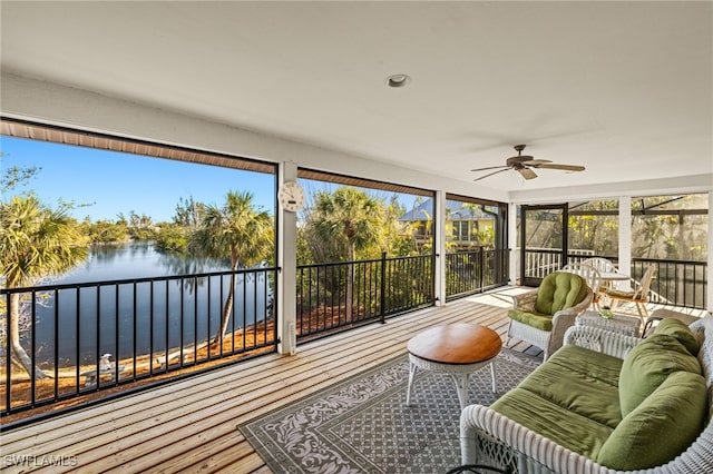 sunroom / solarium with a water view and ceiling fan