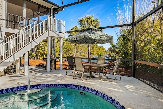 view of swimming pool featuring a lanai and a patio