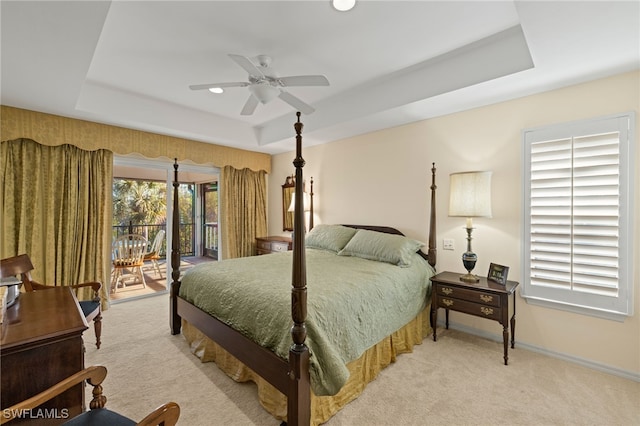 carpeted bedroom featuring ceiling fan, a raised ceiling, and access to outside