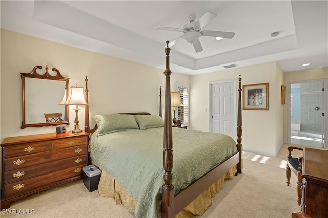 carpeted bedroom featuring ceiling fan and a tray ceiling