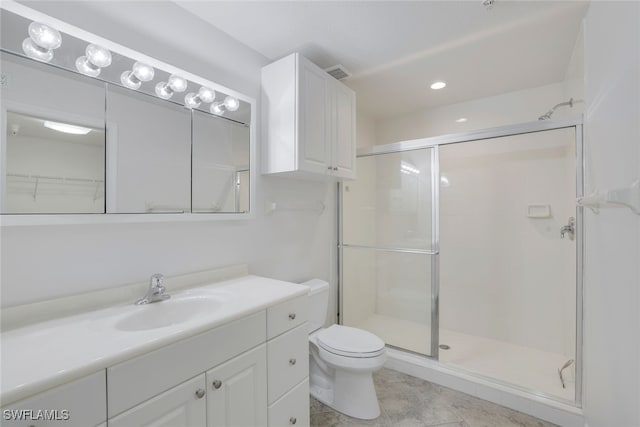 bathroom featuring a shower with door, vanity, and toilet