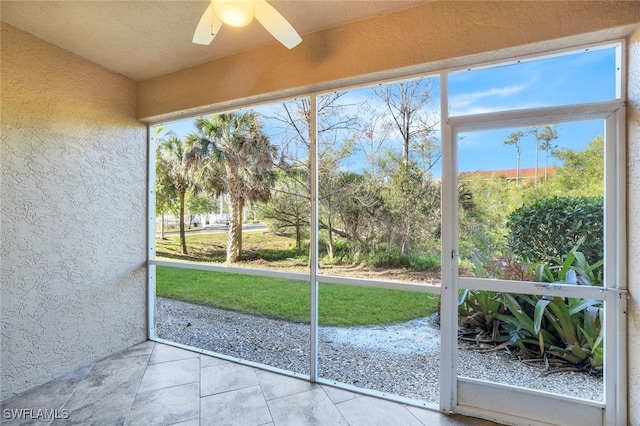 unfurnished sunroom with ceiling fan