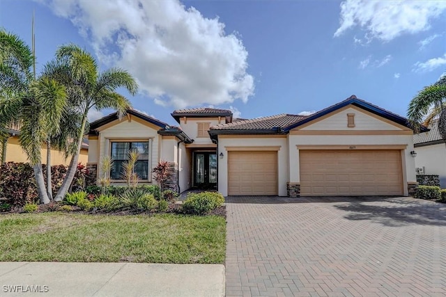 mediterranean / spanish house featuring a garage and a front lawn