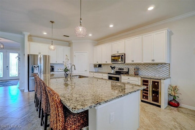 kitchen featuring a large island, appliances with stainless steel finishes, beverage cooler, and sink