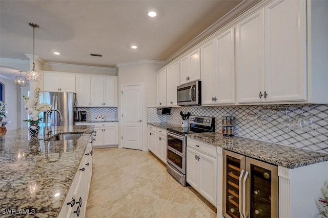 kitchen with appliances with stainless steel finishes, decorative light fixtures, sink, wine cooler, and white cabinets