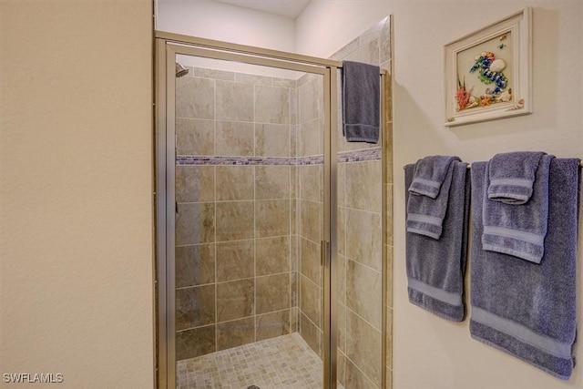 bathroom featuring a shower with door