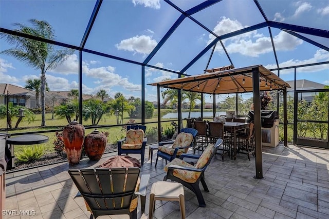 view of patio with a water view, a lanai, and grilling area