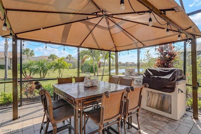 sunroom featuring a water view