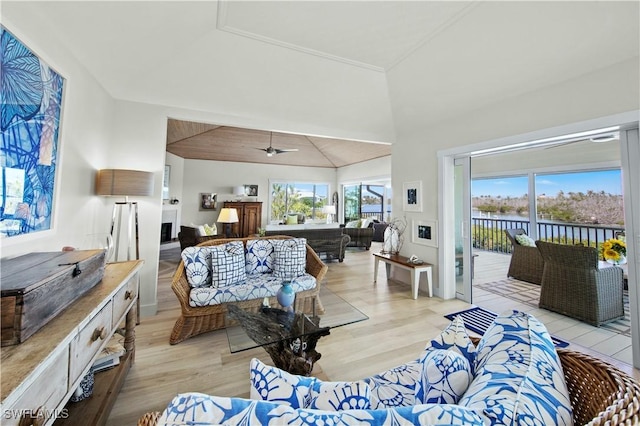 living room featuring a water view, ceiling fan, high vaulted ceiling, and light hardwood / wood-style floors