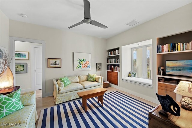 living room featuring ceiling fan and built in features