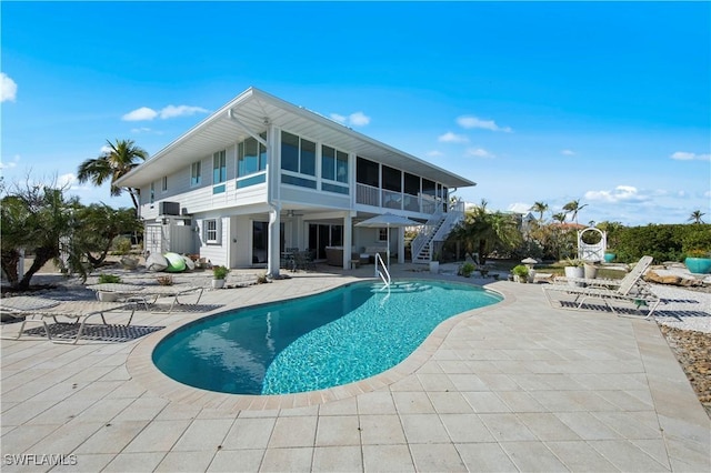 view of pool featuring a sunroom and a patio