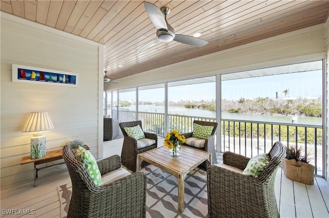 sunroom / solarium featuring wood ceiling, plenty of natural light, ceiling fan, and a water view