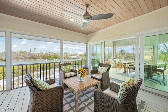 sunroom with ceiling fan, a water view, and wood ceiling