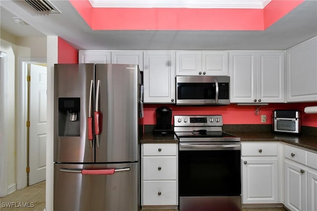 kitchen featuring white cabinetry, ornamental molding, appliances with stainless steel finishes, and light tile patterned floors