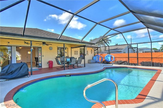 view of pool featuring ceiling fan, a patio area, and glass enclosure