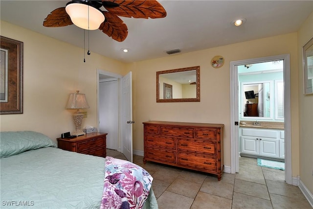 bedroom with light tile patterned flooring, ceiling fan, ensuite bathroom, and sink