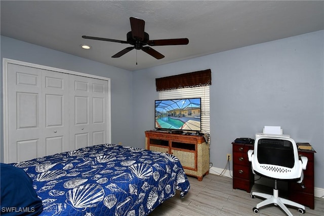 bedroom featuring light hardwood / wood-style flooring, ceiling fan, and a closet