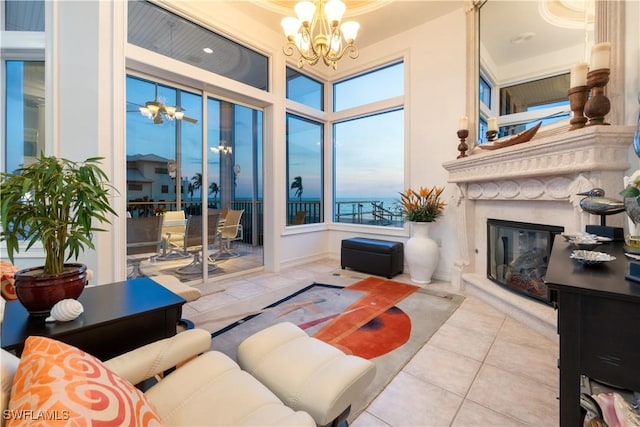 living room featuring a fireplace, light tile patterned flooring, and an inviting chandelier