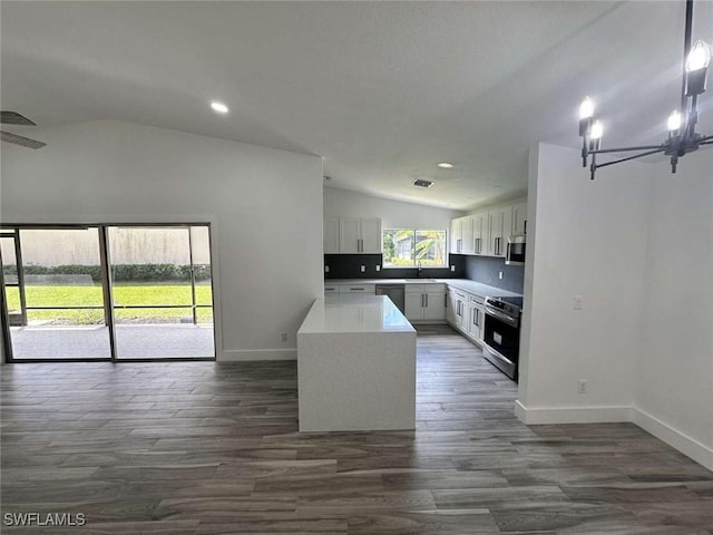 kitchen with lofted ceiling, sink, stainless steel appliances, dark hardwood / wood-style floors, and white cabinets