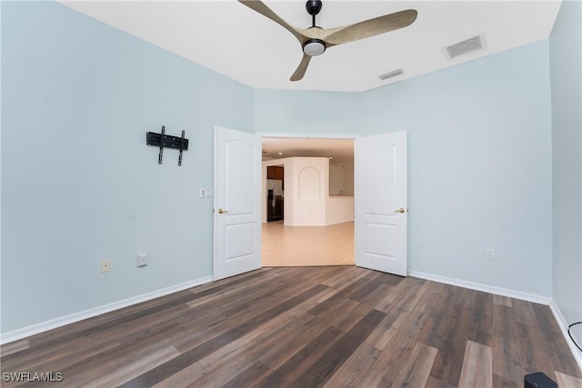 unfurnished room featuring dark wood-type flooring and ceiling fan