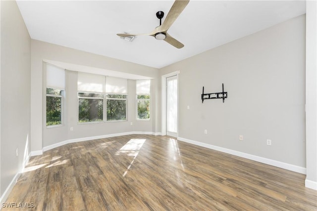 spare room with a ceiling fan, baseboards, and wood finished floors