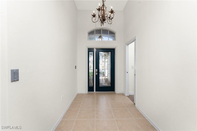 tiled foyer entrance featuring a chandelier and a high ceiling