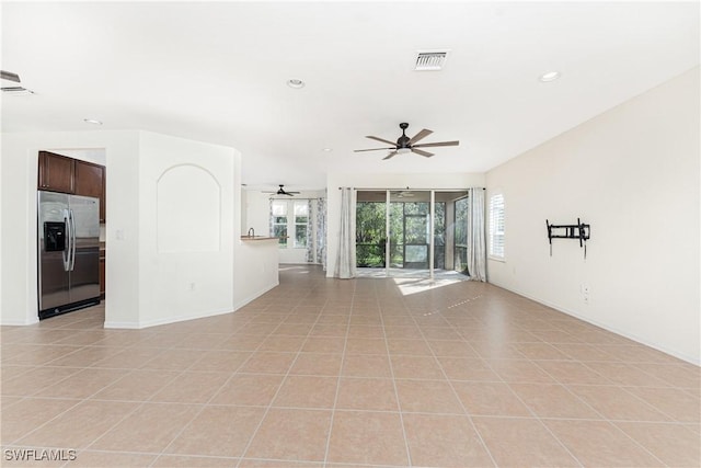 unfurnished living room featuring ceiling fan, a healthy amount of sunlight, and light tile patterned floors