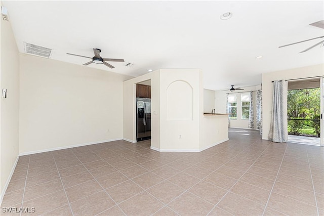 unfurnished living room featuring light tile patterned floors and ceiling fan