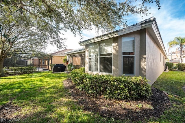 rear view of house with a yard and stucco siding