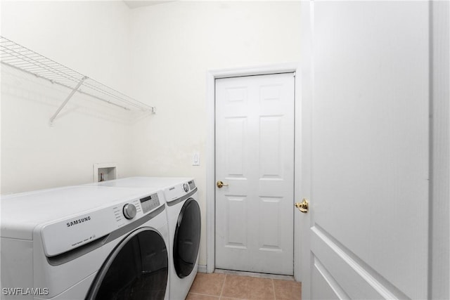 clothes washing area with laundry area, light tile patterned flooring, and washer and dryer