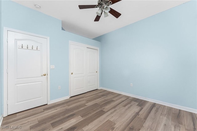 unfurnished bedroom featuring ceiling fan, light hardwood / wood-style floors, and a closet