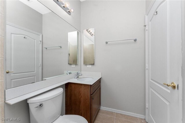 bathroom featuring vanity, tile patterned floors, and toilet