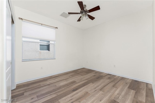 empty room with ceiling fan and light hardwood / wood-style flooring