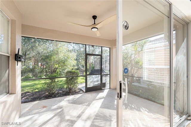 unfurnished sunroom with ceiling fan