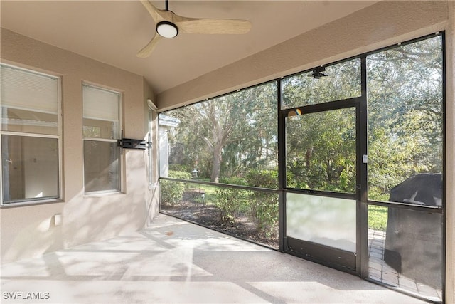 unfurnished sunroom featuring a wealth of natural light and ceiling fan