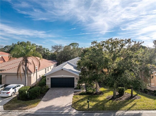 view of front of property with a garage and a front lawn