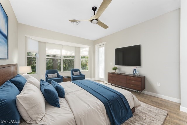 bedroom with baseboards, ceiling fan, and light wood finished floors