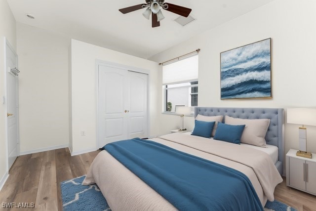 bedroom with a closet, ceiling fan, baseboards, and wood finished floors