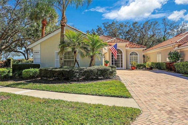 mediterranean / spanish-style home with a front yard