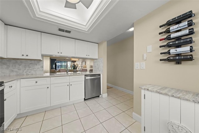 kitchen with white cabinetry, dishwasher, a raised ceiling, and light tile patterned floors