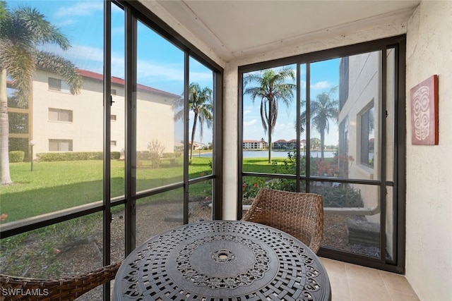 sunroom / solarium featuring a water view