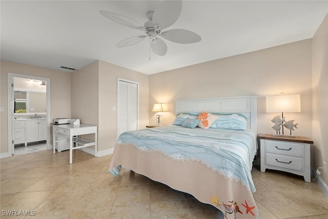 tiled bedroom featuring ceiling fan, ensuite bathroom, sink, and a closet