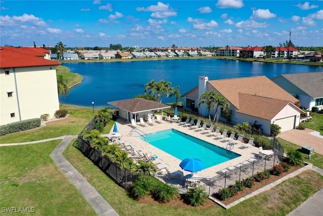 view of swimming pool featuring a water view, a yard, an outdoor structure, and a patio