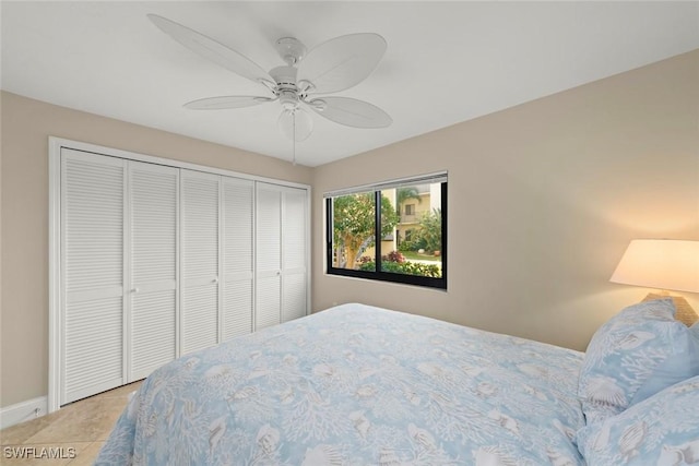 tiled bedroom featuring ceiling fan and a closet